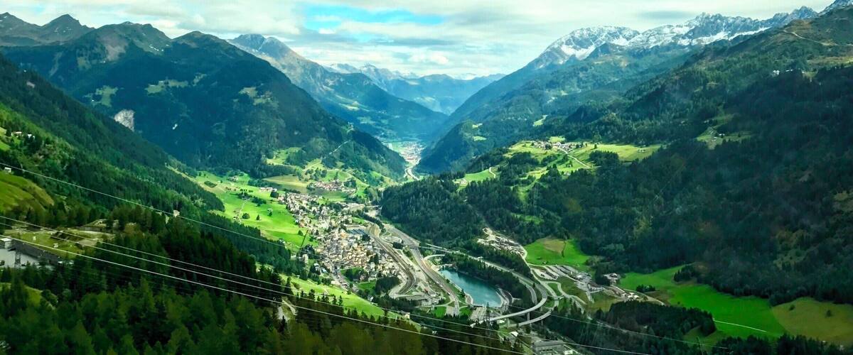 A valley with a river, mountains, and a town.
