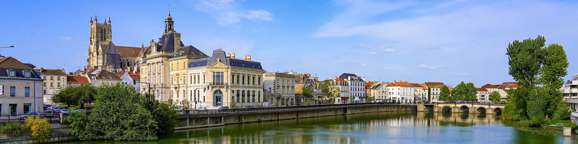 A river with a bridge, a cathedral, and surrounding buildings.