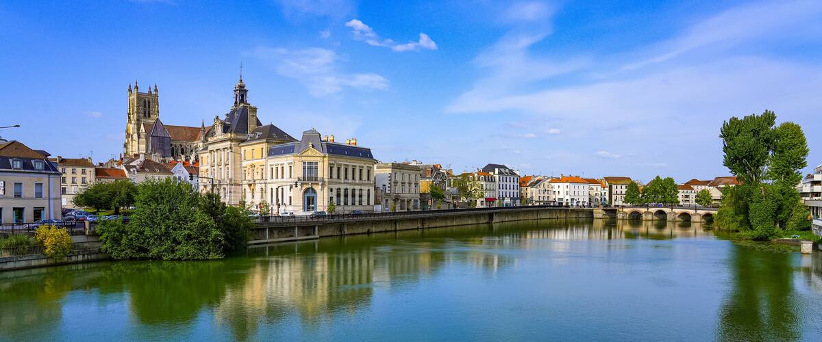 A river with a bridge, a cathedral, and surrounding buildings.
