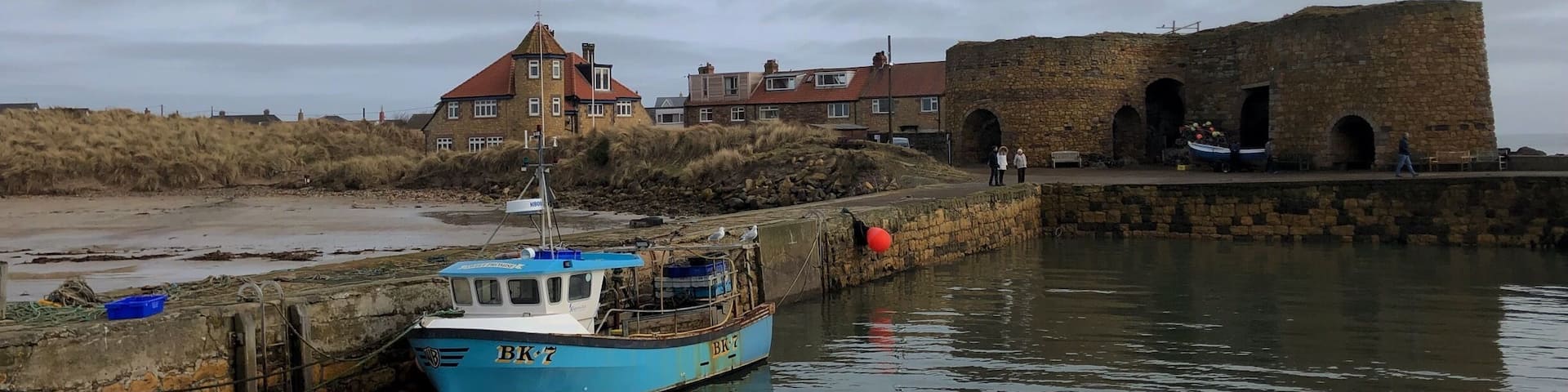Beadnell harbour and lime kiln. One of my favourite breaches in the world. Large beach is a bay bordered by sand dunes.