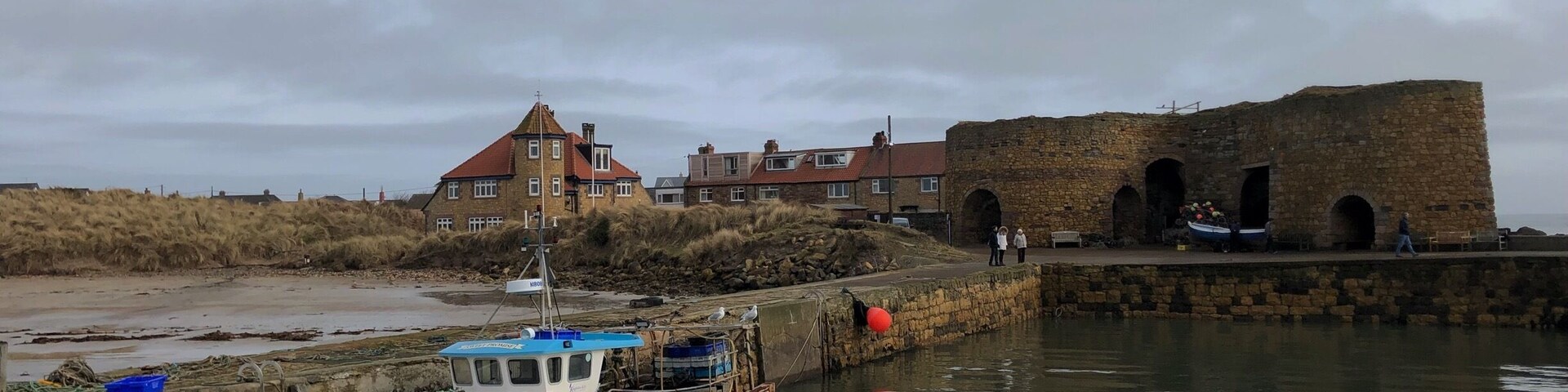 Beadnell harbour and lime kiln. One of my favourite breaches in the world. Large beach is a bay bordered by sand dunes.