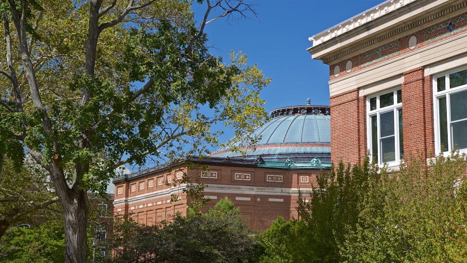 A brick building with a dome and a statue on top.