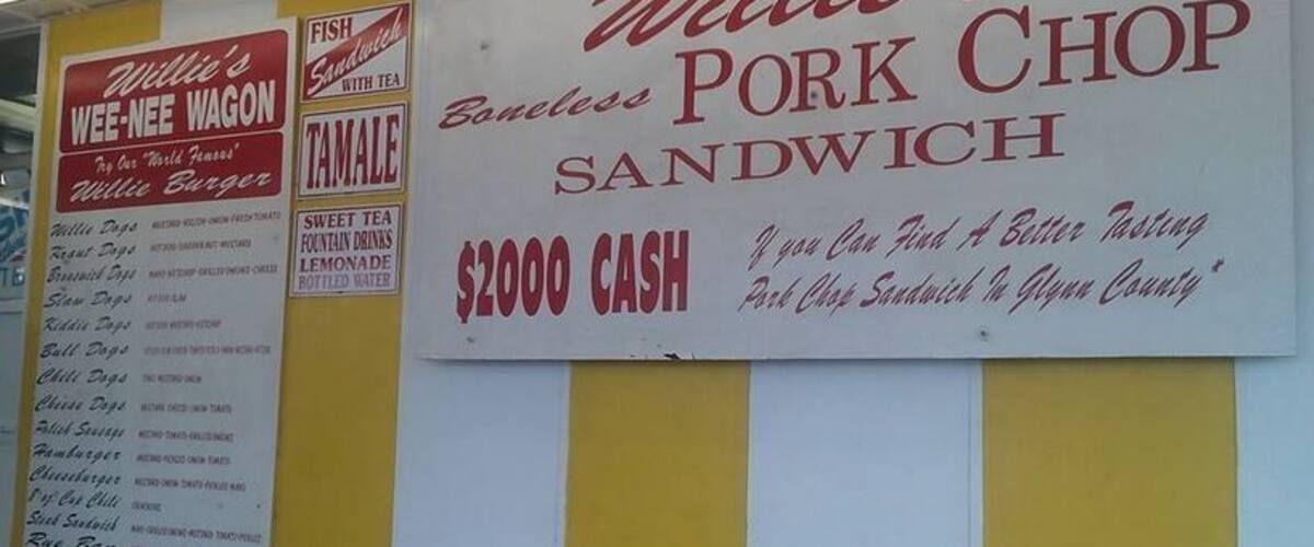 A menu board for Willie's Pork Chop Sandwich with a $2000 cash offer.