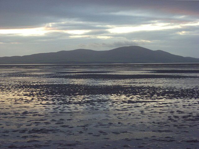 A beach with a mountain in the background.