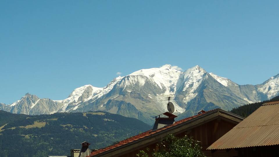 A mountain range with snow-capped peaks and a clear blue sky.
