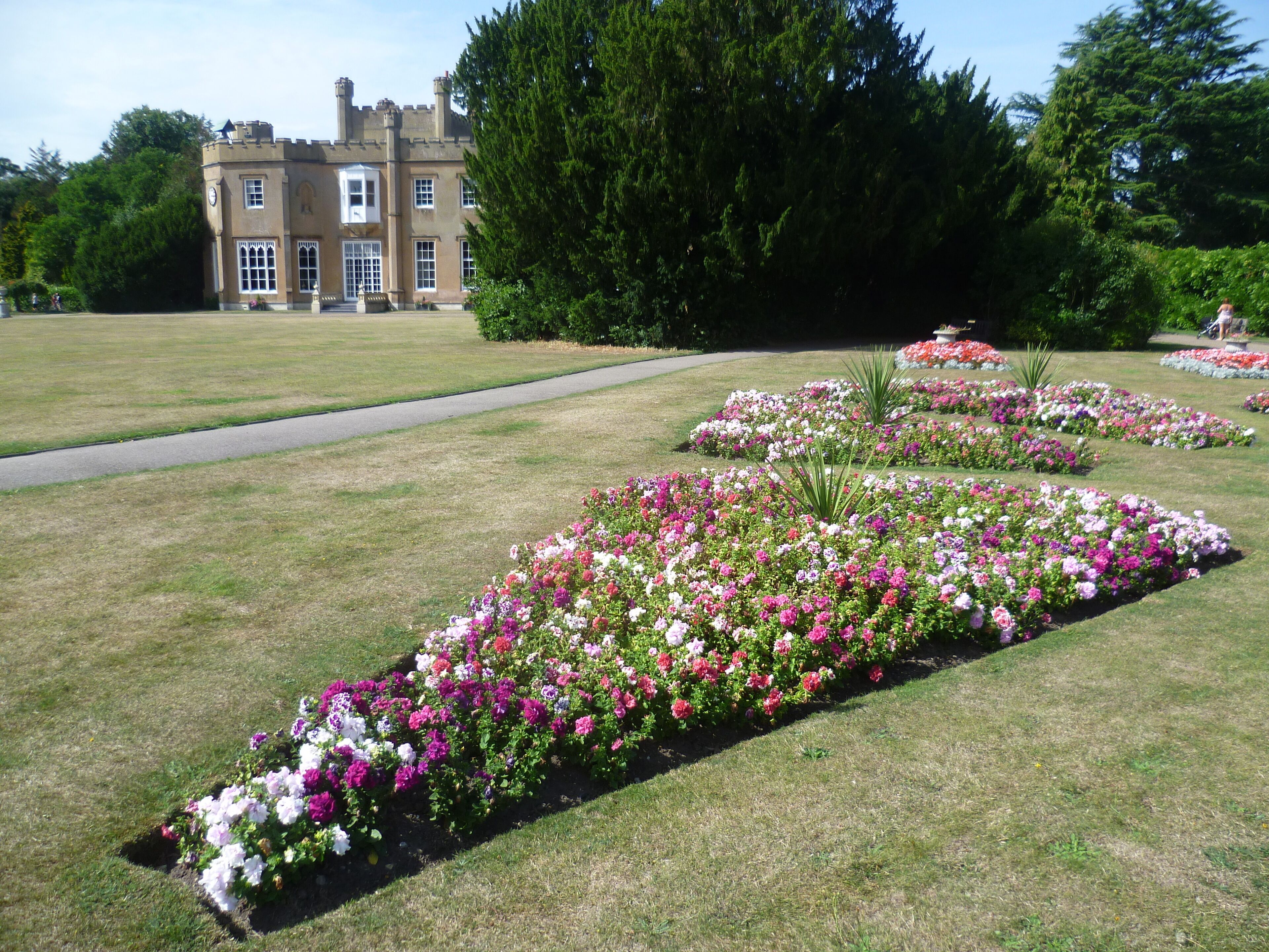 A large estate with manicured flower beds and a castle-like building.