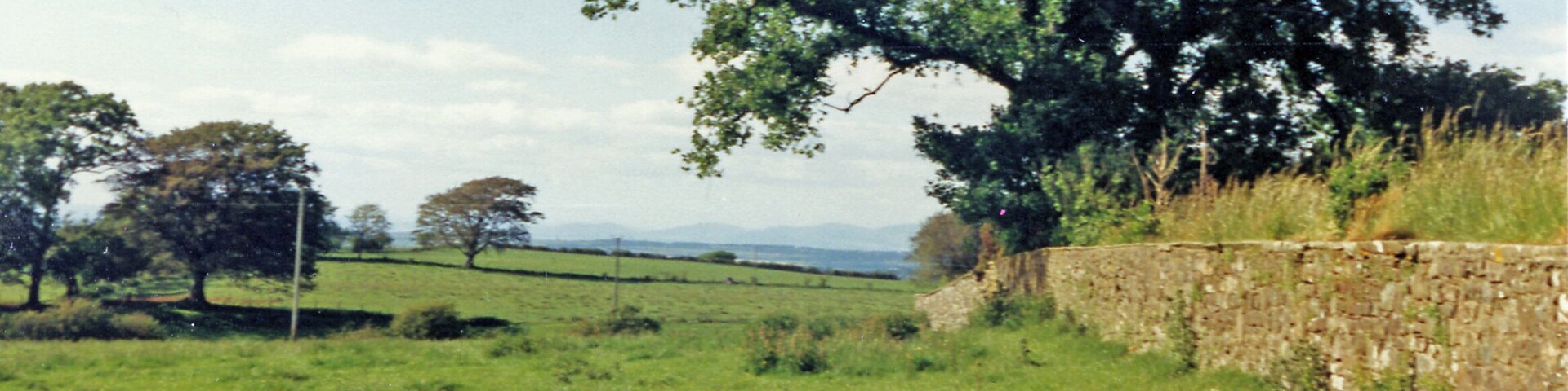 Lamplugh: NW view by St Michael's Church, 1986. It was a fine clear day for once and on the horizon Criffell (1,866 ft.) is just visible on the Scottish side of the Solway. This was once my land, as Lord of the Manor of Lamplugh and in the weeds of the churchyard on the right are my father's ashes in a family grave. (See also NY0820 : Lamplugh: St Michael's Parish Church, 1986).