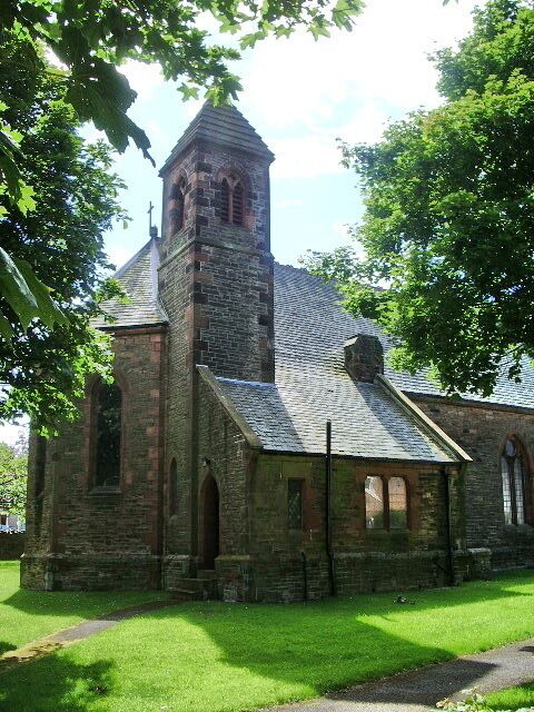 A stone church with a bell tower and arched windows.