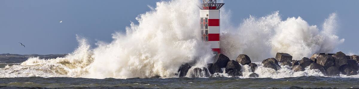 Un phare aux rayures rouges et blanches, entouré de vagues déferlantes.