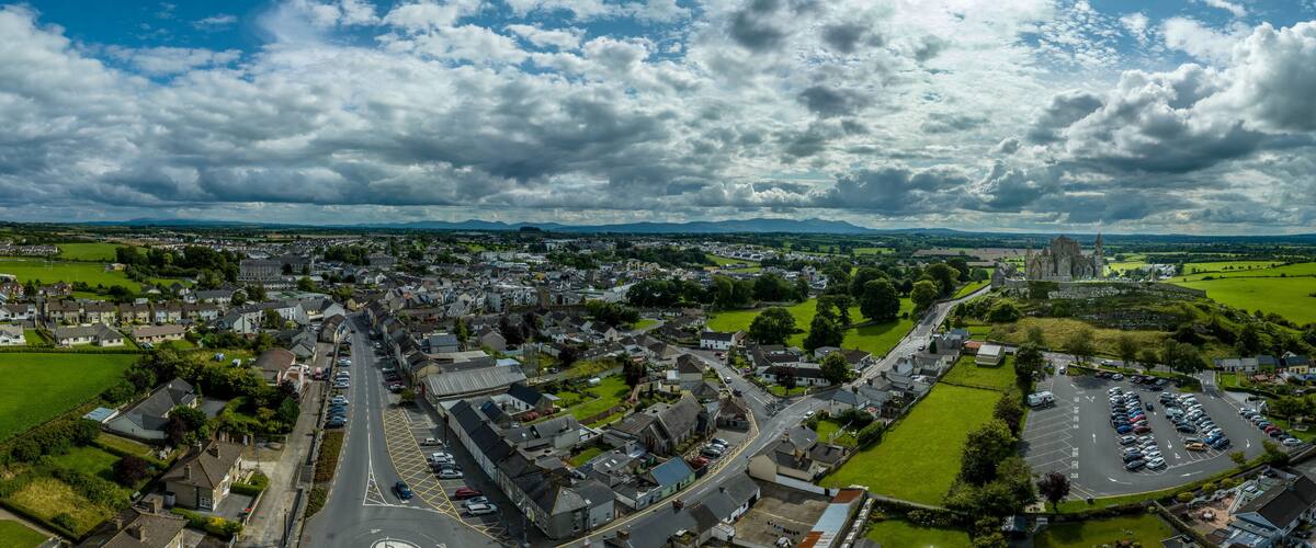 A town with a prominent church, green fields, and a parking lot.