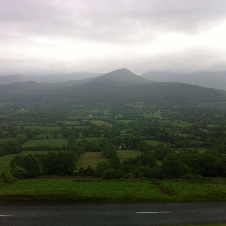 A valley with rolling hills and a mountain in the distance.