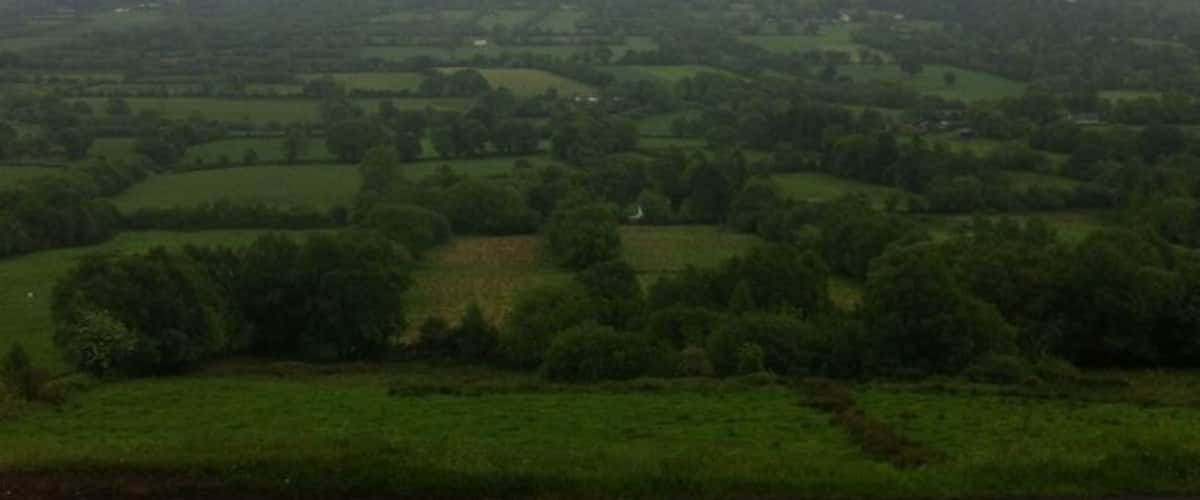 A valley with rolling hills and a mountain in the distance.