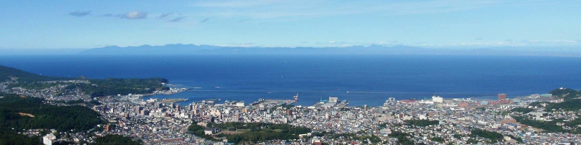 天狗山から見る小樽市街地。石狩湾越しに増毛山地を遠望する。