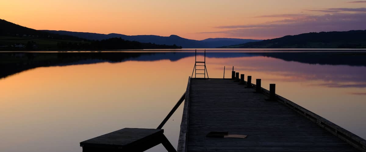 Norwegian lake at sunset with silhouette of pier, Jevnaker, Norway