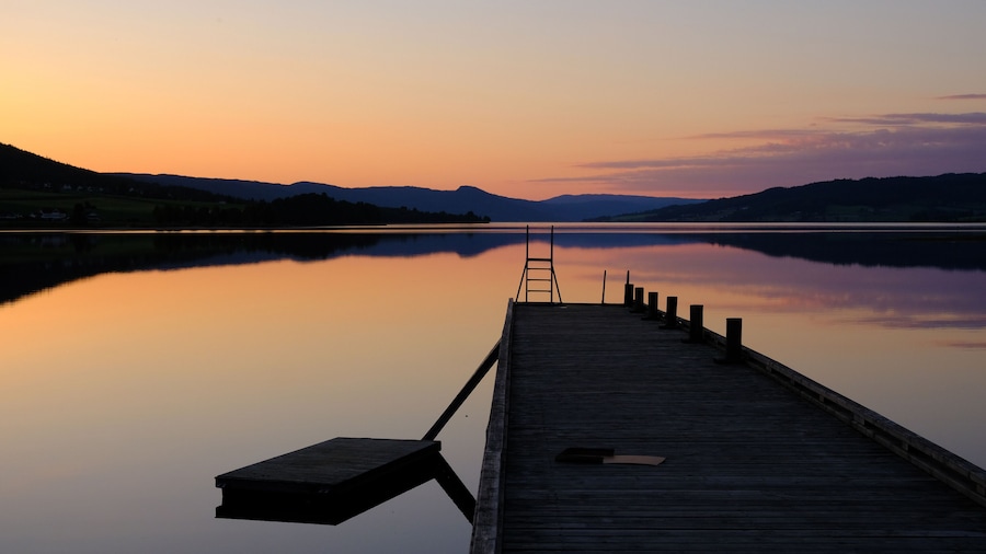 Norwegian lake at sunset with silhouette of pier, Jevnaker, Norway