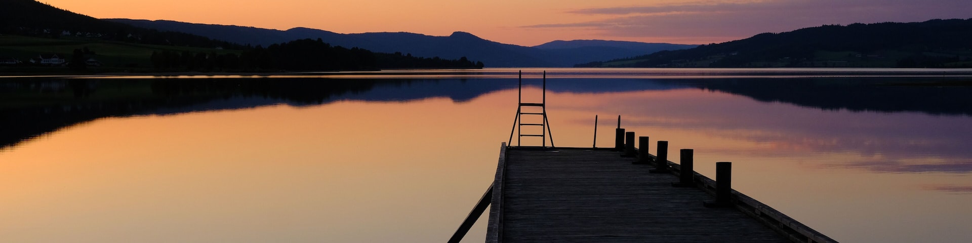 Norwegian lake at sunset with silhouette of pier, Jevnaker, Norway