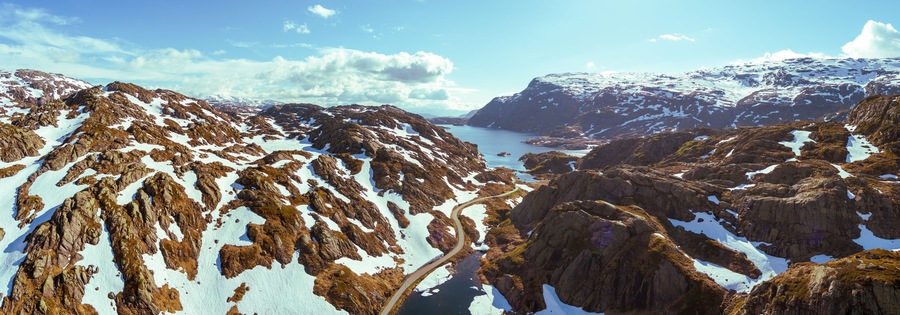 Mountain landscape in summer. Aerial view at glacier melted lake, mountains ridge, and highway. Nature park in Sauda municipality, Rogaland fylke. Beautiful nature of Norway. Horizontal banner