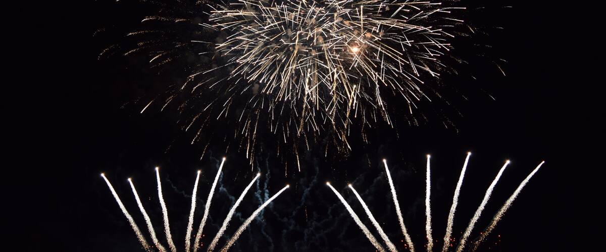A night sky with fireworks exploding in various patterns.