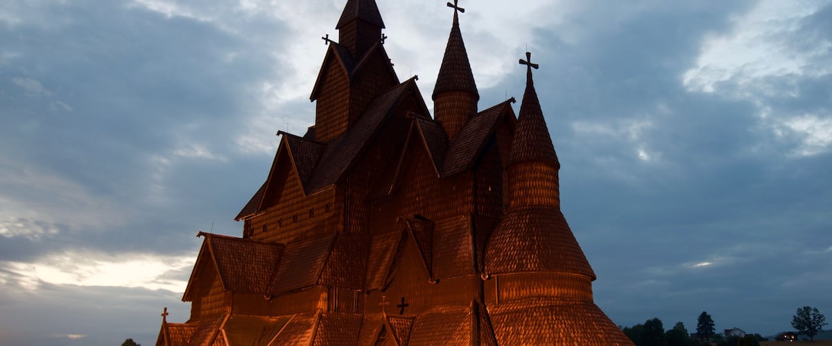 A wooden church with multiple spires and crosses, surrounded by gravestones.