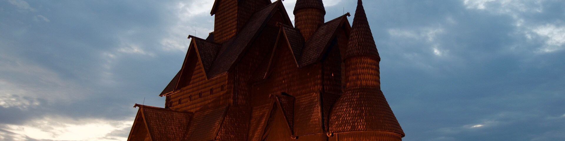 A wooden church with multiple spires and crosses, surrounded by gravestones.
