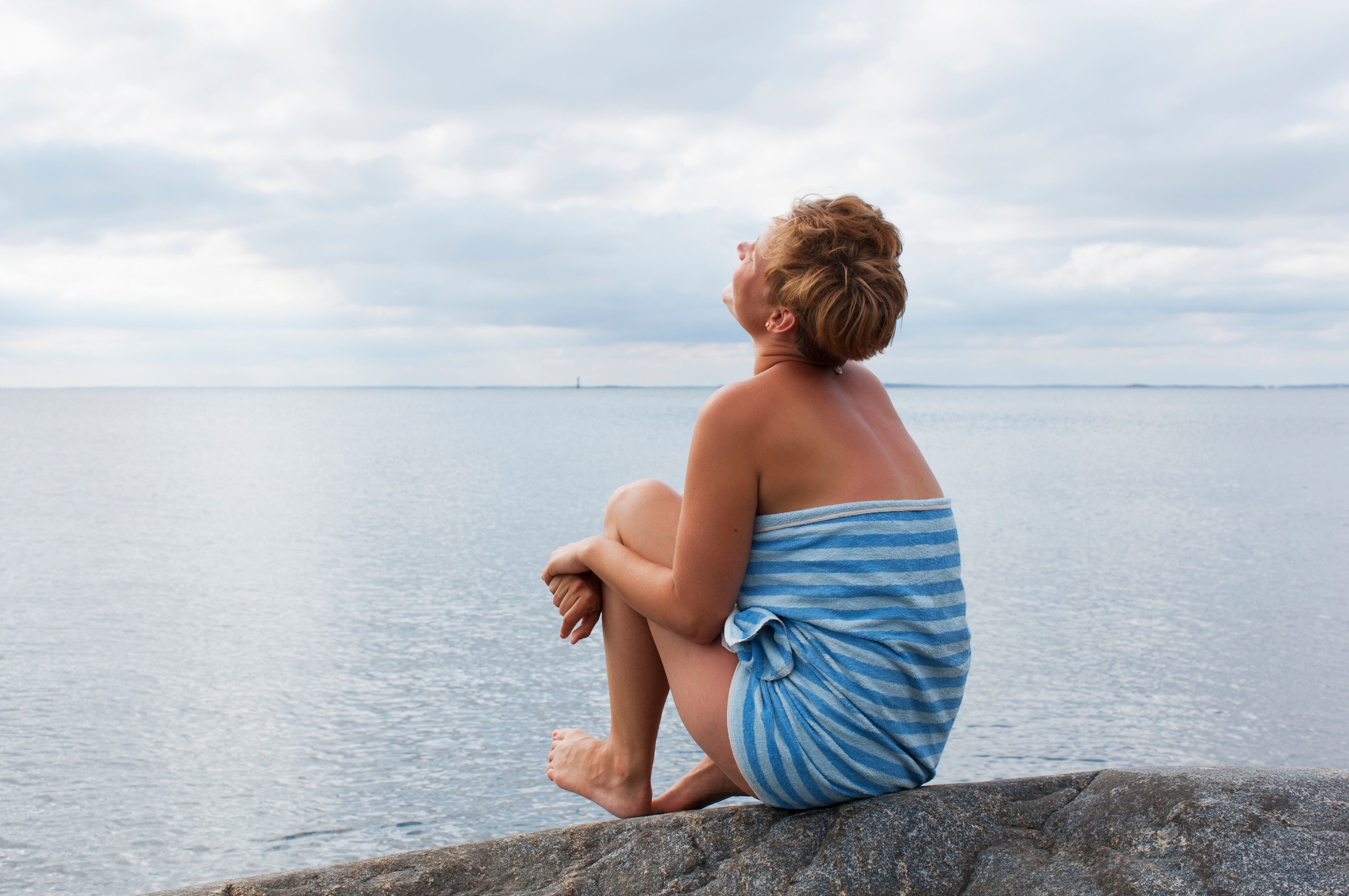 Sweden, Sodermanland, Stockholms Archipelago, Landsort, Woman relaxing by Baltic sea