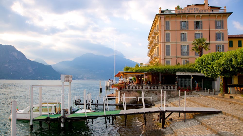Ein Steg am See mit Booten, einem Restaurant und einem Gebäude mit Balkonen.