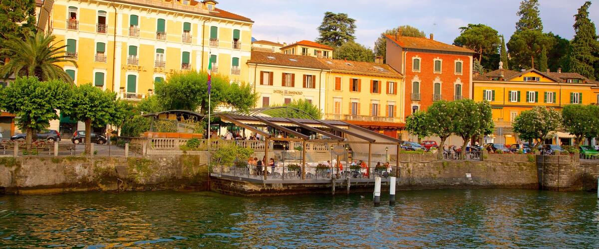 Un paseo marítimo con edificios históricos, un puente y una cafetería.
