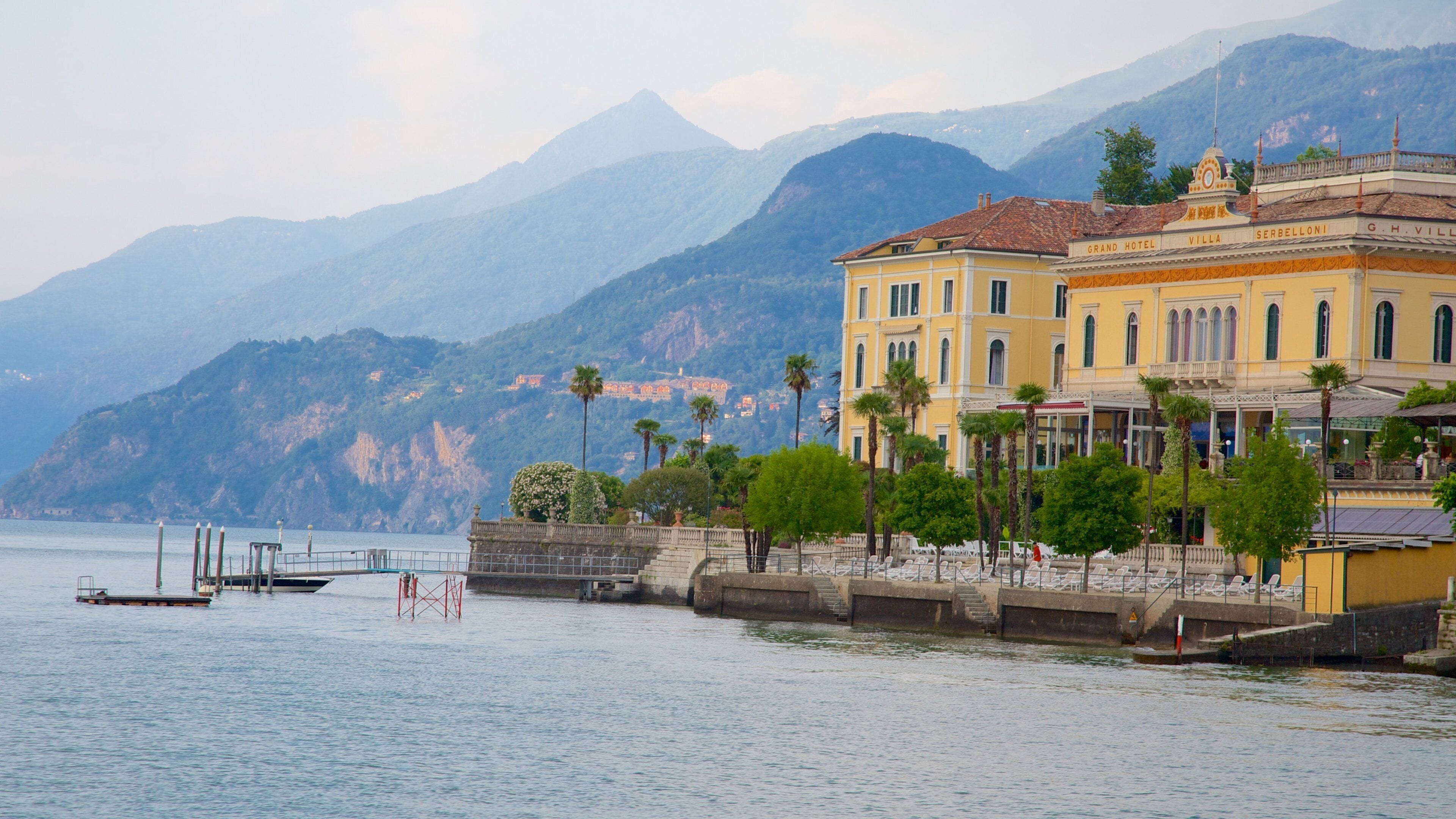 A waterfront hotel with a mountain backdrop.