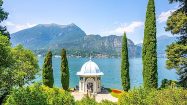 A gazebo by a lake with mountains in the background.