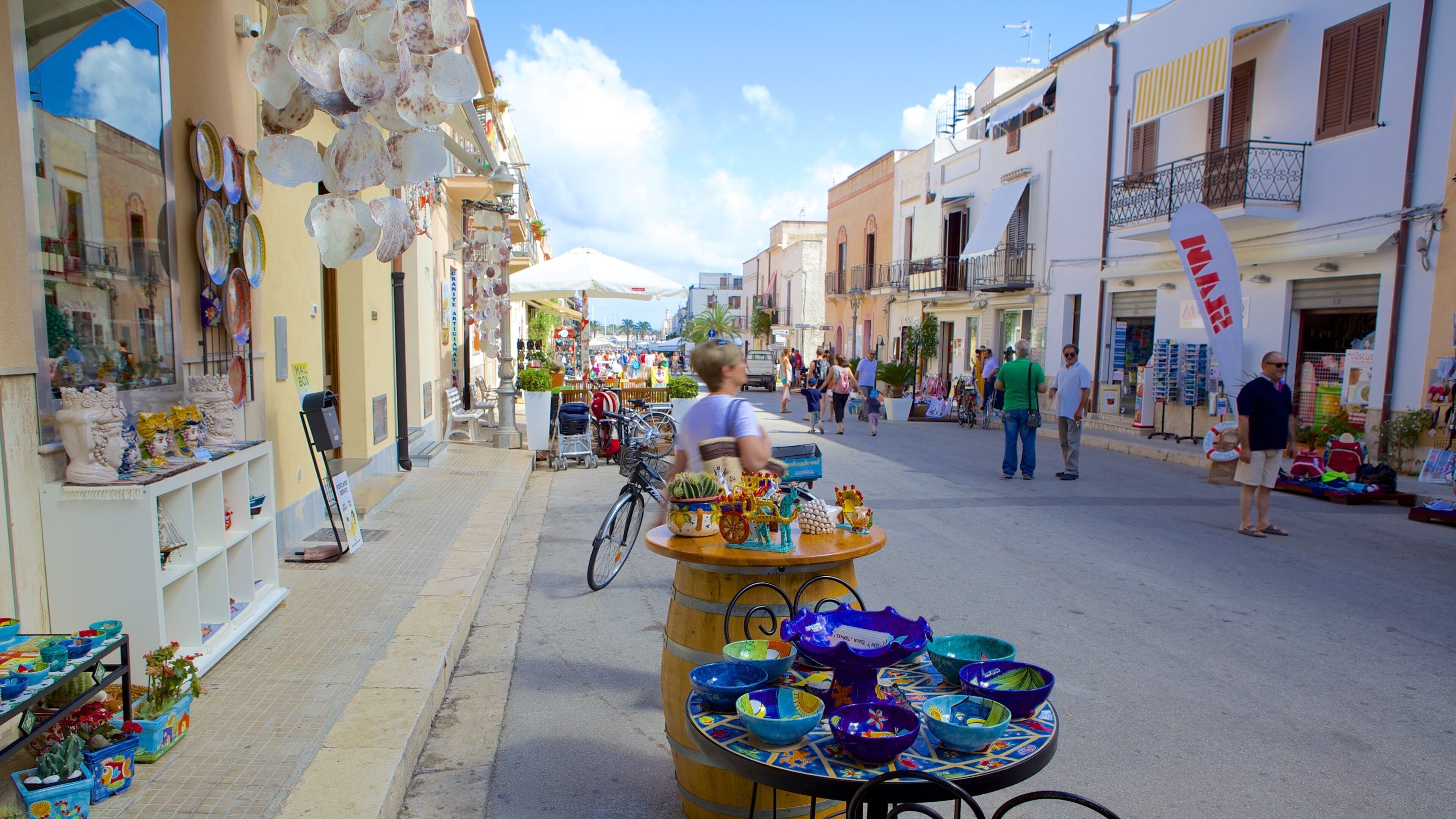 A bustling street market with colorful pottery and a variety of stalls.