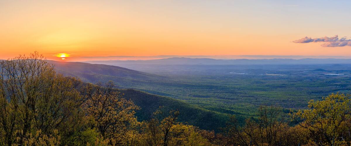 A mountainous landscape with a sunset.