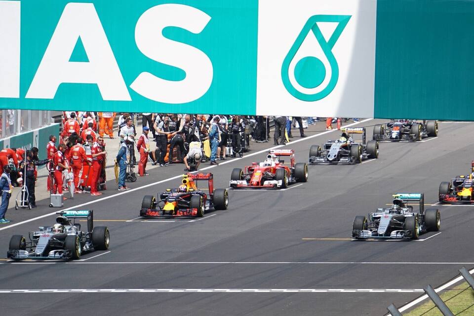 A Formula 1 race on a track with multiple cars and teams.