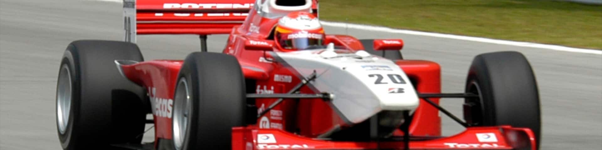 Racing car speeds around the track in Sepang, Selangor, Malaysia during a bright sunny day
