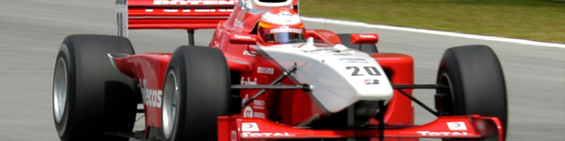Racing car speeds around the track in Sepang, Selangor, Malaysia during a bright sunny day