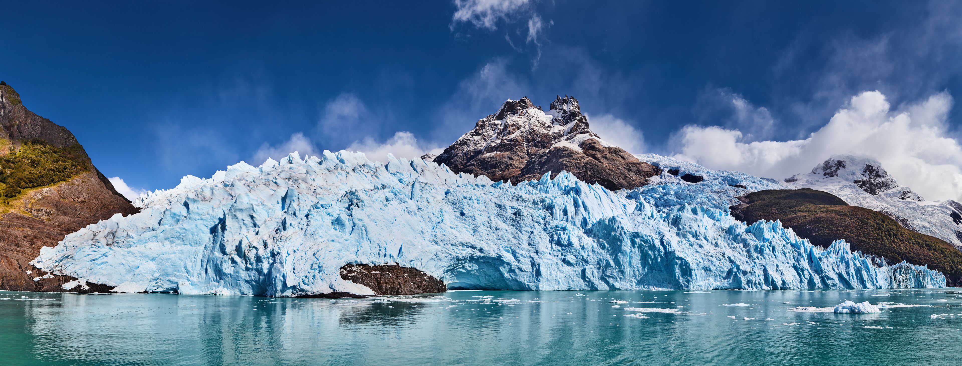 Un glaciar con un pico prominente y acantilados rocosos circundantes.