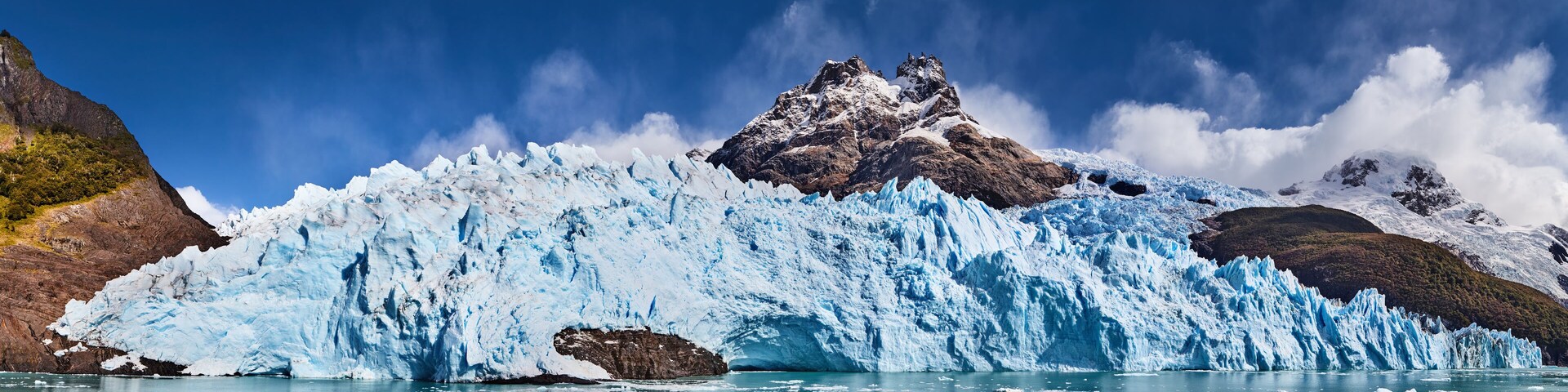 Un glaciar con un pico prominente y acantilados rocosos circundantes.
