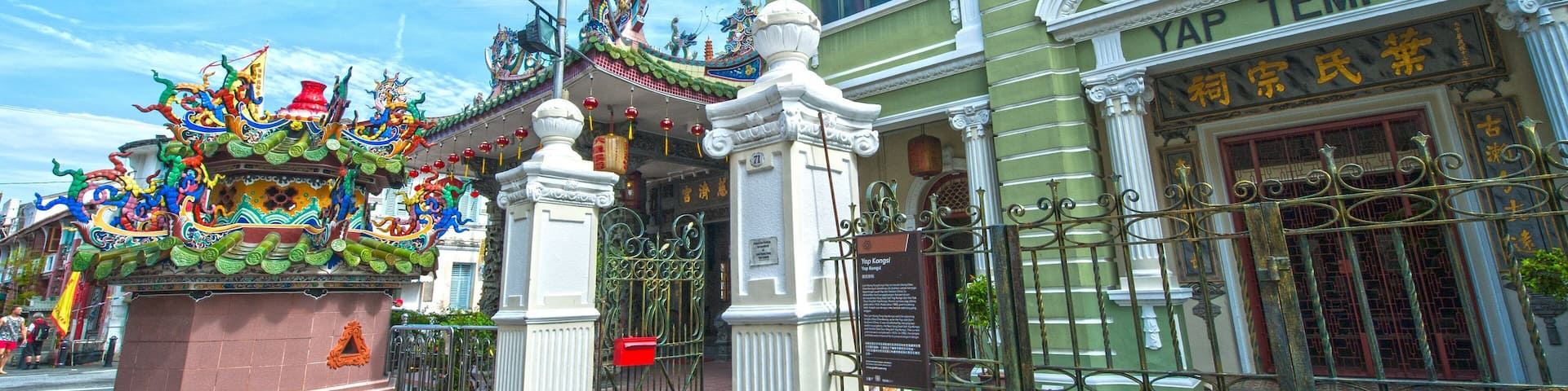 A temple with ornate Chinese architecture, a colorful dragon sculpture, and a sign reading "YAP TEMPLE".