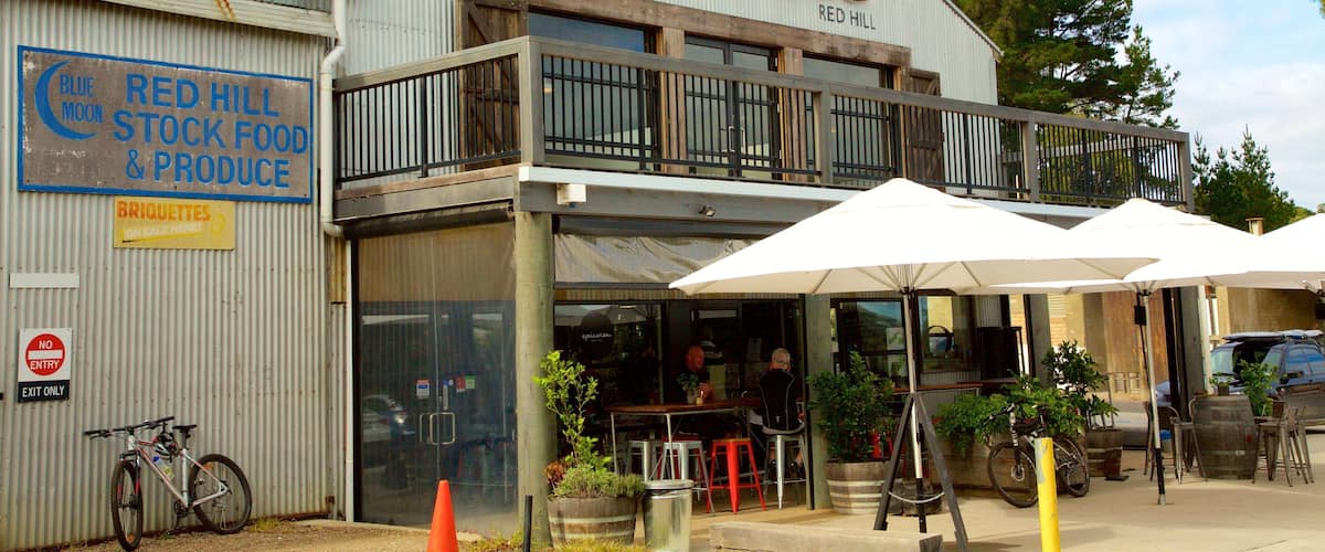 A restaurant named 'epicurean' with outdoor seating and a sign for 'Red Hill Stock Food & Produce'.