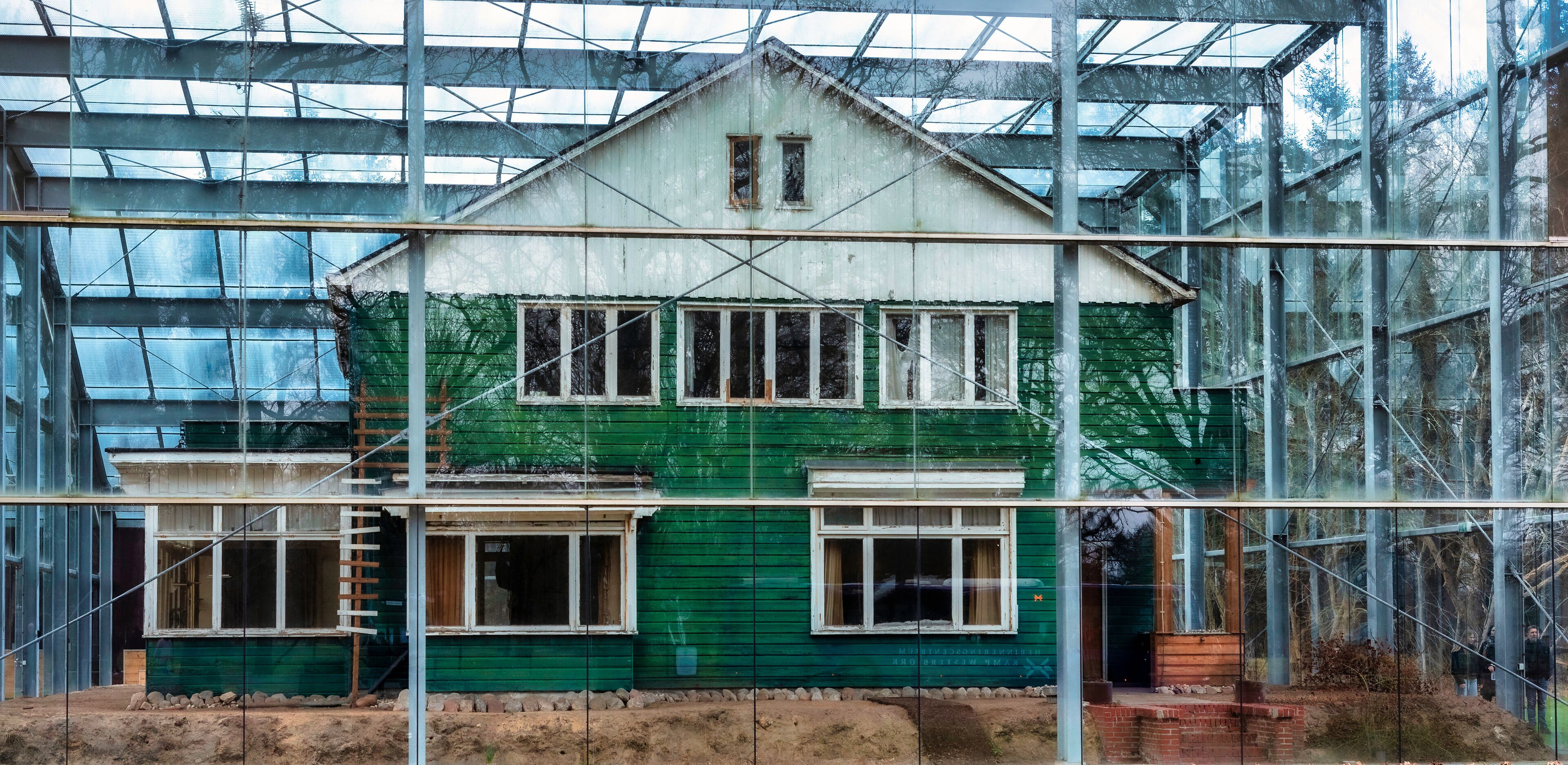 A green house under construction with scaffolding and a glass greenhouse structure in the background.