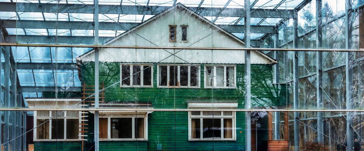 A green house under construction with scaffolding and a glass greenhouse structure in the background.