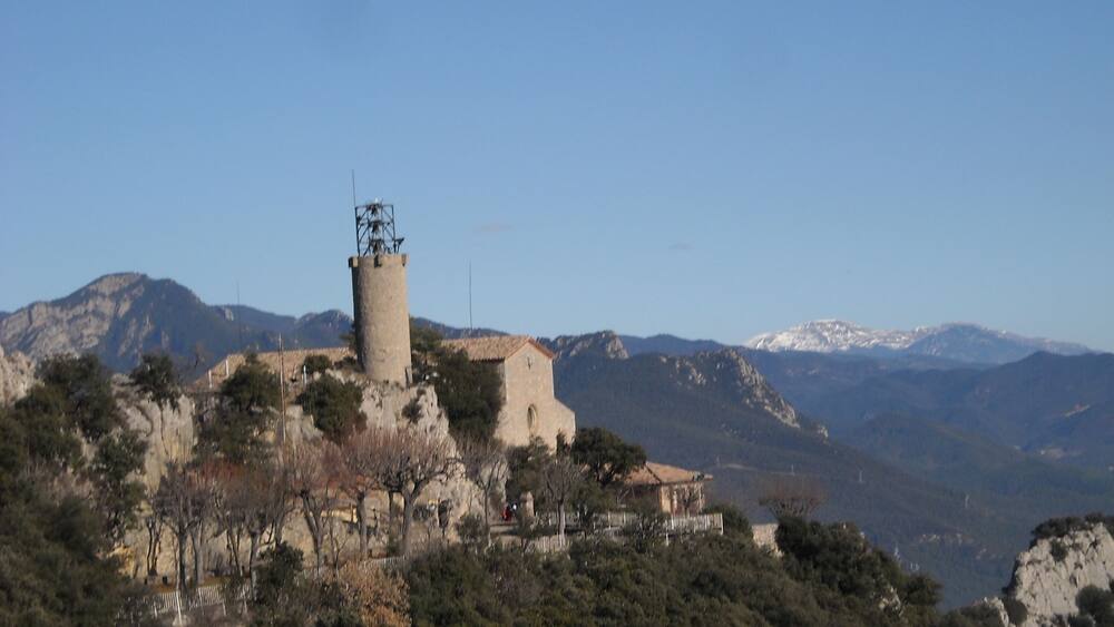 A tower on a hill with a clear sky.