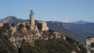 A tower on a hill with a clear sky.