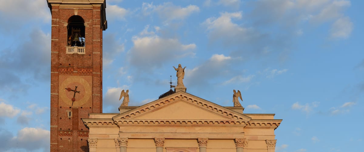 A church with a bell tower and a statue on top.