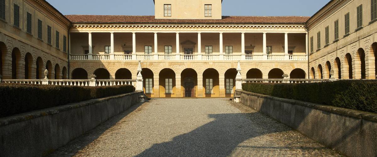 A classical building with a central portico, arched windows, and a symmetrical facade.