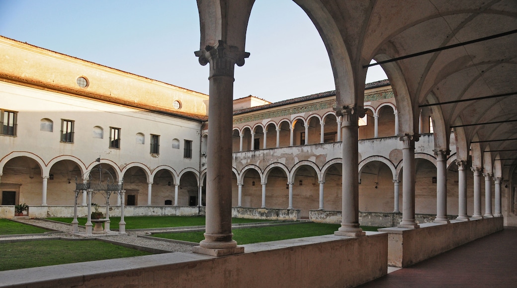 An ancient cloister with a central courtyard, surrounded by arched walkways and columns.