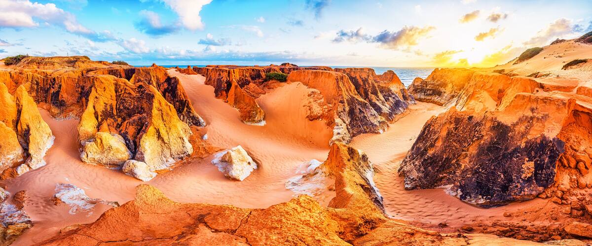 Un paisaje agreste con formaciones rocosas erosionadas y un río que serpentea por un cañón.