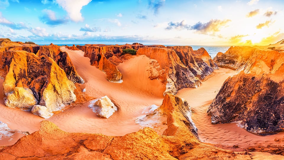 Un paisaje agreste con formaciones rocosas erosionadas y un río que serpentea por un cañón.