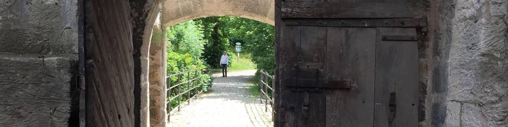 An old stone archway leading to a cobblestone path.