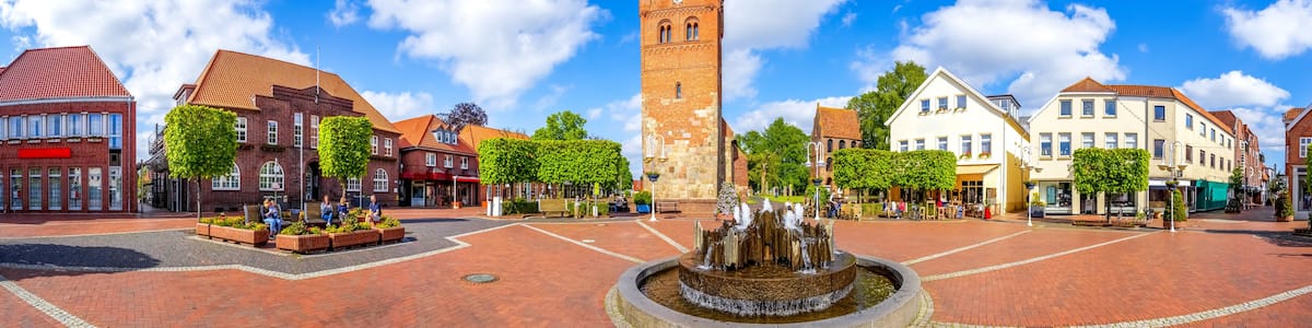 A town square with a prominent tower, a fountain, and historic buildings.