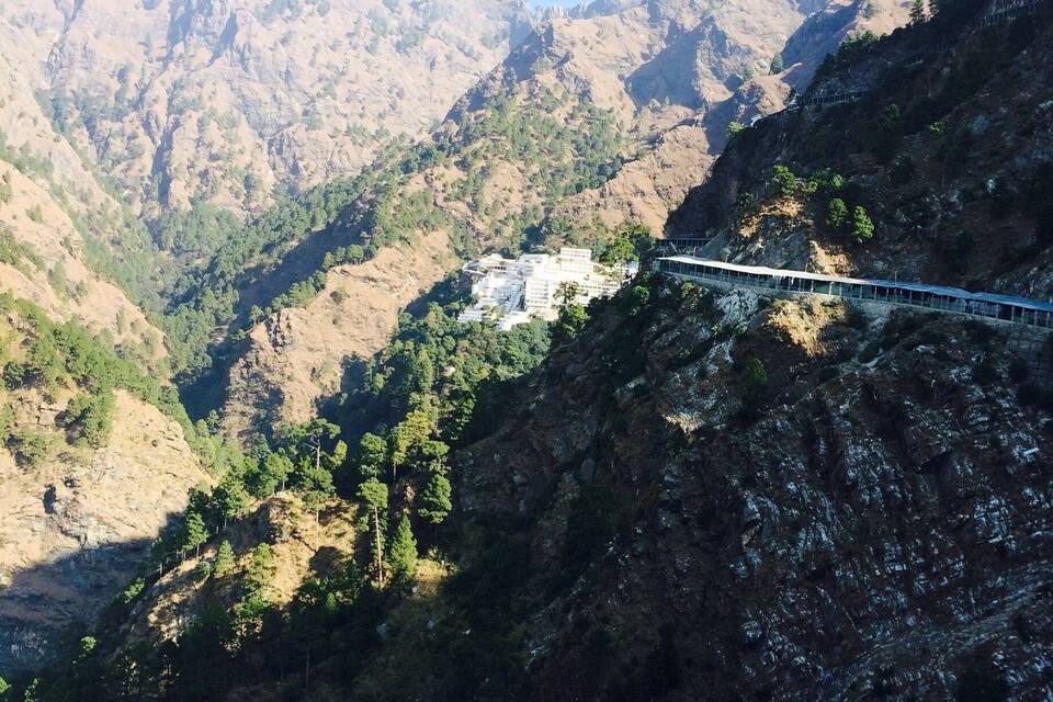 Un pont telefèric sobre una vall, amb muntanyes al fons.